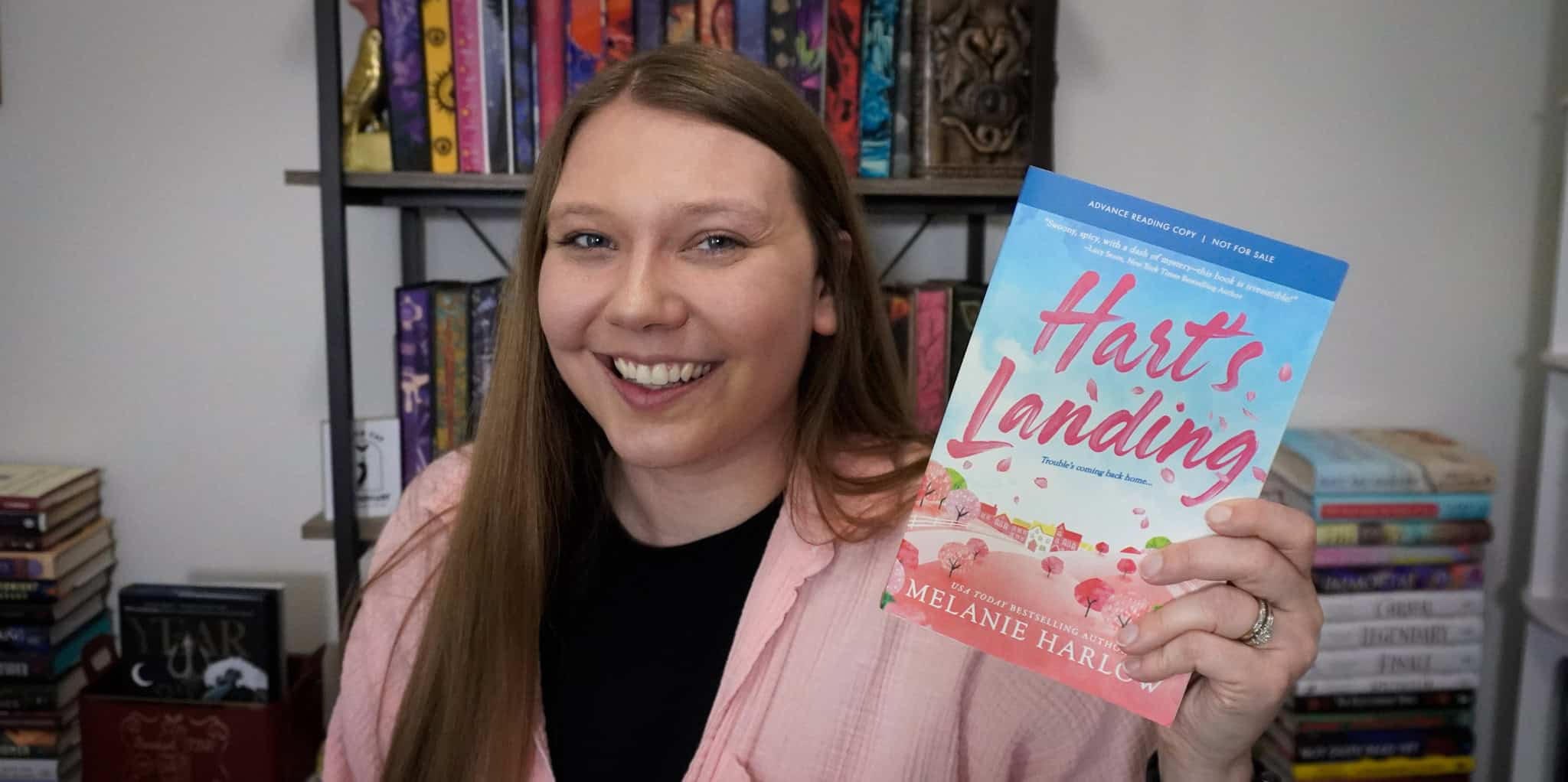 Harts Landing book cover by Melanie Harlin, featuring pink and blue design held by Sierra