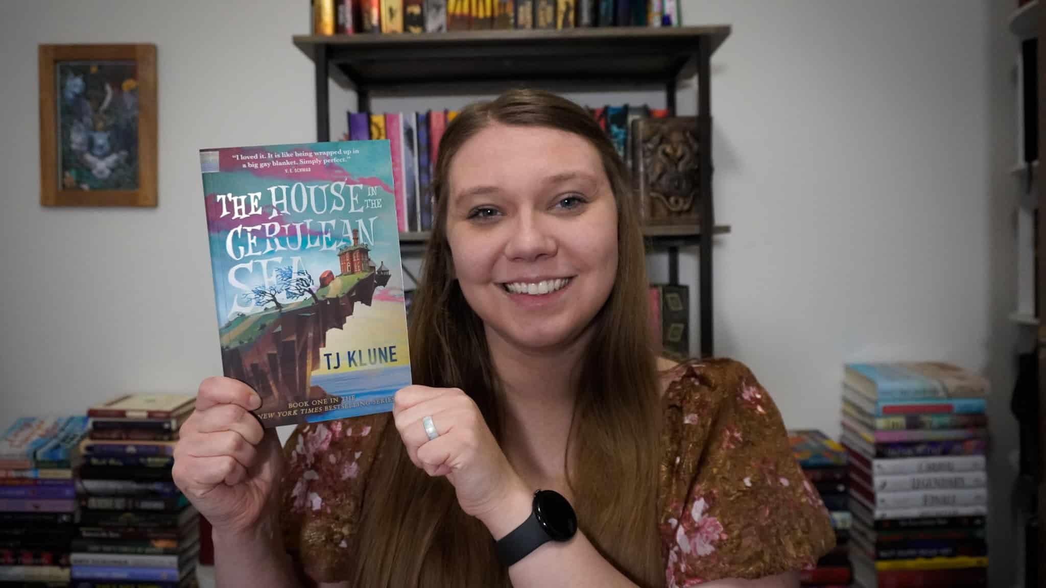 Sierra showing off the cover of The House in the Cerulean Sea